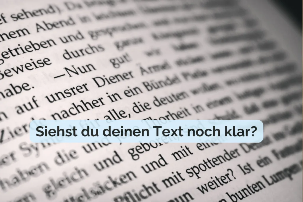 Unscharf fotografierte Buchseite mit Text, darüber der Schriftzug „Siehst du deinen Text noch klar?“